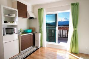 a kitchen with a large window with a mountain view at Yushin in Fujikawaguchiko