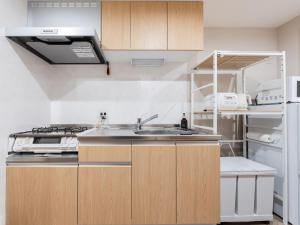 a kitchen with a sink and a refrigerator at fleuve tenmonkan in Yamashitachō
