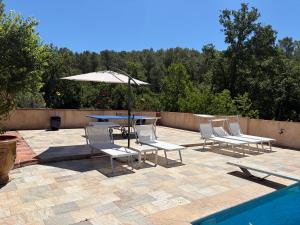 a patio with a table and chairs and an umbrella at La Gran Vigne in Salernes