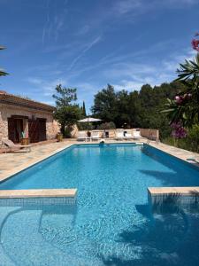 a large swimming pool with blue water in a yard at La Gran Vigne in Salernes