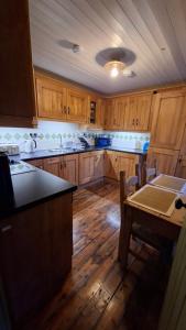 a kitchen with wooden cabinets and a table in it at The Point by the Sea in Carraroe +21 photos