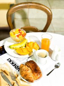 a white table topped with a plate of food and fruit at Villa malaka in Dakar