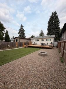 a large yard with a house and a fence at Bright & Fully Renovated Retreat - Holiday Home in Saskatoon