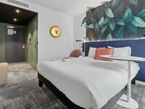 a bedroom with a large bed and a table at ibis Styles Bezons Paris La Défense in Bezons +61 photos