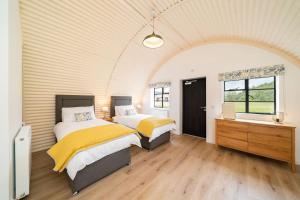 a bedroom with two beds and a window at Cultybraggan Hut 37 in Comrie