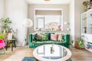 a living room with a green couch and a glass table at Walpole Bay Sea Views in Margate