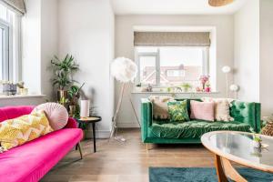 a living room with two green couches and a glass table at Walpole Bay Sea Views in Margate