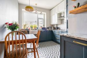 a kitchen with blue cabinets and a table and chairs at Walpole Bay Sea Views in Margate +69 photos