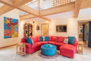 a living room with a red couch and a table at Beautiful backyard pool deeded beach rights in Truro