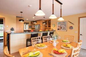 a dining room and kitchen with a table and chairs at Beautiful backyard pool deeded beach rights in Truro