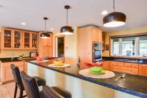 a kitchen with wooden cabinets and a counter with bowls on it at Beautiful backyard pool deeded beach rights in Truro +43 photos