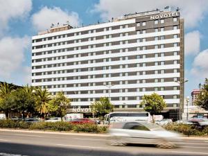 a white car driving in front of a hotel at Novotel Valencia Lavant in Valencia
