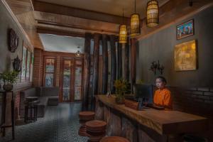 a woman sitting at a desk with a laptop at BB Angkor Residence in Siem Reap