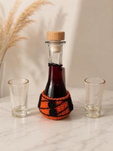 a bottle of vinegar with two glasses on a table at Room Jakov in Šibenik +17 photos