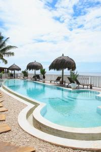 a swimming pool with umbrellas and the ocean at ZAN Island Beach in Jambiani +70 photos