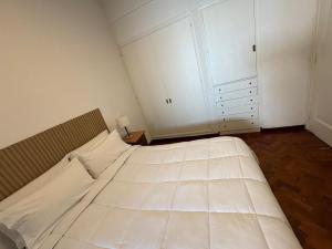 a bedroom with a large white bed and a closet at Casa flora Bed and Breakfast in San Juan