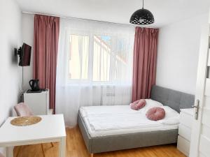 a bedroom with a bed with pink pillows on it at U KAZI in Niechorze