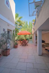 a patio with a table and an umbrella at Central villa flatlet with pool - free parking and WiFi in Lija