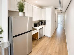 a kitchen with white cabinets and a refrigerator at The Accessible Atom | Historic Main in St. Charles