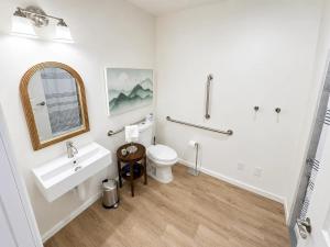 a white bathroom with a sink and a toilet at The Accessible Atom | Historic Main in St. Charles +4 photos