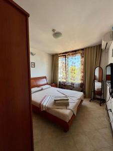 a bedroom with a bed and a window at Oasis Resort Apartments in Lozenets +33 photos