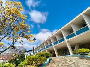 a large white building with trees in front of it at Hotel Tijuco Turismo in Diamantina