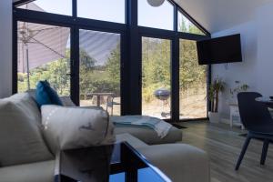 a living room with a couch and large windows at Welsh Marches at Upper Glyn Farm in Wolves Newton
