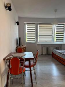 a room with a table and chairs and a bed at Ośrodek Wczasowy Daga in Dziwnów