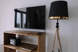 a lamp with a black lamp shade next to a television at ZAN Island Beach in Jambiani