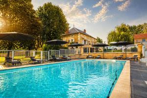 a swimming pool with umbrellas and chairs and a house at La biche au bois piscine chauffee jacuzzi in Cazals