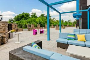 a patio with blue couches and tables at Tru By Hilton Princeton in Princeton