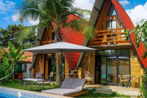 a house with an umbrella next to a swimming pool at Cabañas Alpinas en Oxapampa in Oxapampa