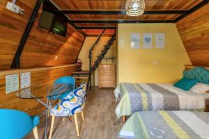 a bedroom with a bed and a table and chairs at Cabañas Alpinas en Oxapampa in Oxapampa +43 photos