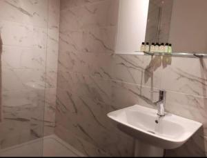 a white bathroom with a sink and a mirror at Horans Bar and Restaurant in Baltinglass