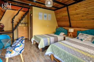 a bedroom with two beds and a table and chairs at Cabañas Alpinas en Oxapampa in Oxapampa