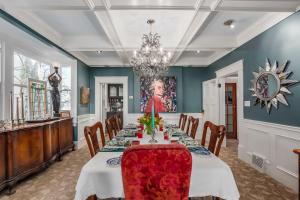a dining room with a table and chairs and a chandelier at West End Guest House in Vancouver