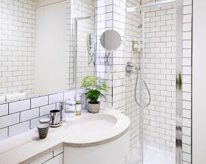 a white bathroom with a sink and a shower at No.5 Maddox Street in London +16 photos