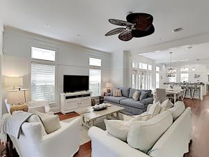 a living room with white furniture and a flat screen tv at Watercolor Whimsea in Seagrove Beach
