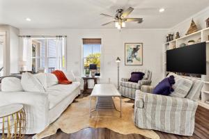 a living room with white furniture and a flat screen tv at Easy Breezy in Santa Rosa Beach