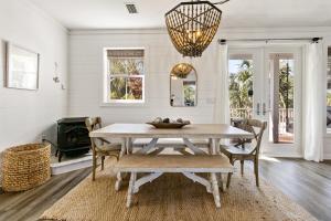 a dining room with a table and chairs and a chandelier at Easy Breezy in Santa Rosa Beach