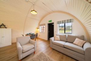 a living room with a couch and a chair at Cultybraggan Hut 38 - Accessible in Comrie