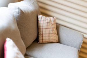 a plaid pillow sitting on a gray couch at Cultybraggan Hut 38 - Accessible in Comrie