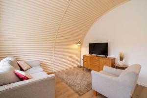 a living room with two chairs and a television at Cultybraggan Hut 38 - Accessible in Comrie +24 photos