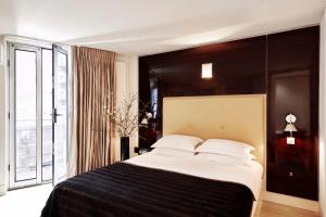 a bedroom with a large bed and a large window at No.5 Maddox Street in London