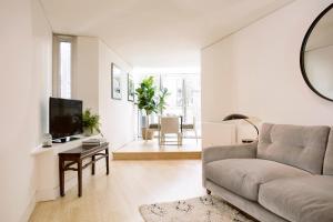 a living room with a couch and a tv at No.5 Maddox Street in London