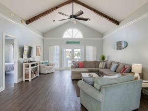 a living room with a couch and a ceiling fan at Sunglow Bungalow in Pensacola Beach