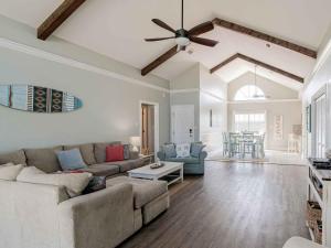 a living room with a couch and a ceiling fan at Sunglow Bungalow in Pensacola Beach