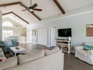 a living room with a couch and a flat screen tv at Sunglow Bungalow in Pensacola Beach +32 photos