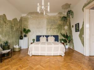 a bedroom with a bed with a blue and white comforter at City Center Boutique Apartments - Schlossberg View - Free Parking in Graz