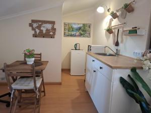 a kitchen with a table and a sink and a counter at Quartos confortáveis em casa próximo ao Mosteiro in Batalha